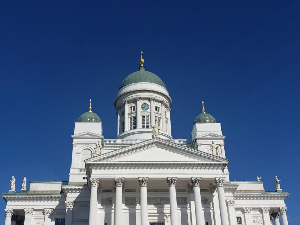 White Helsinki building with green domes.